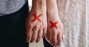 married couple red x on hands